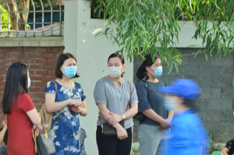 Trong lúc chờ đợi thí sinh làm bài thi, các bậc phụ huynh luôn đeo khẩu trang và giữa khoảng cách an toàn để phòng chống dịch Covid-19.