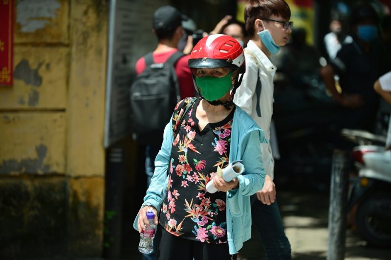 Hình ảnh người bà đứng nắng đợi cháu tại cổng trường