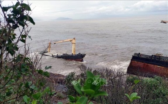 Tàu chở hàng mắc cạn đã bị sóng đánh gãy đôi. (Ảnh: TTXVN)