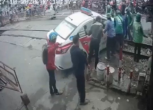 Giải cứu chiếc taxi mắc kẹt trên đường ray tàu hoả