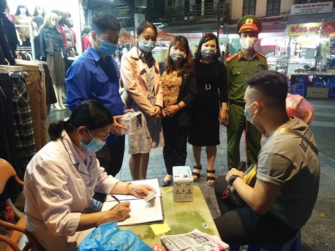 Lực lượng chức năng ra quân xử phạt vi phạm không đeo khẩu trang tối 6/11. (Ảnh: CAND)
