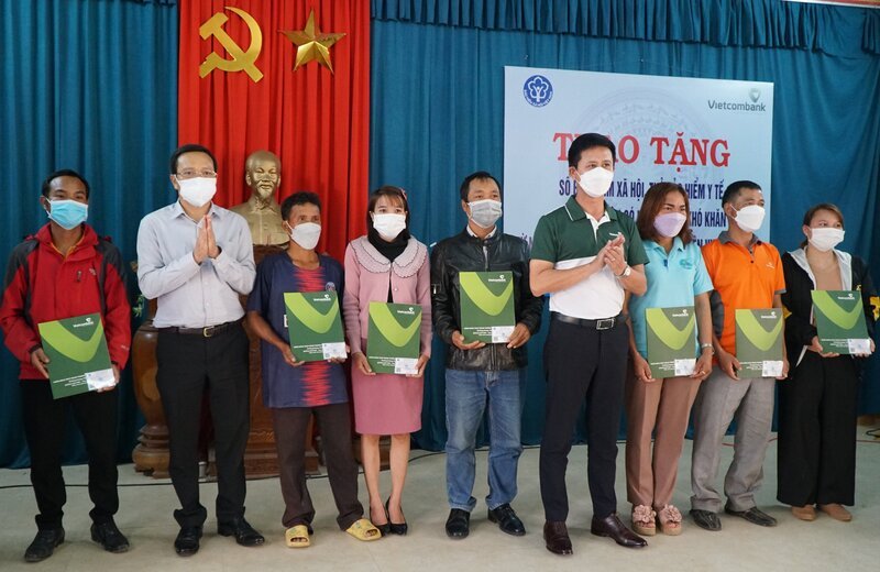 Tặng sổ BHXH và thẻ BHYT cho người dân khó khăn.