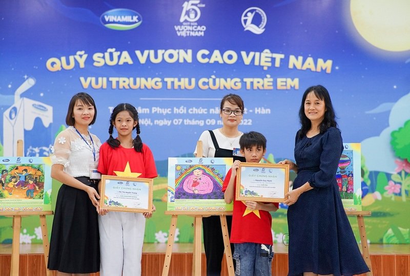 Em Phí Thị Huyền Trang (giải khuyến khích) và Nguyễn Duy Mạnh (giải ba) nhận quà từ đại diện công ty Vinamilk 