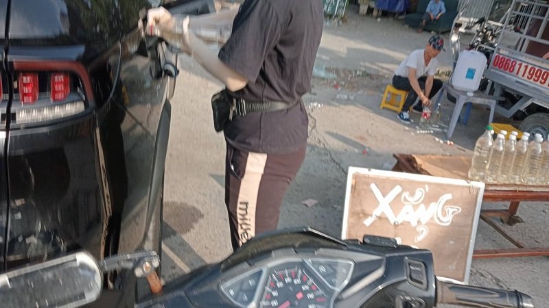 Một ô tô hết xăng phải vào đổ xăng với giá cắt cổ. (Ảnh: Phương Nam).