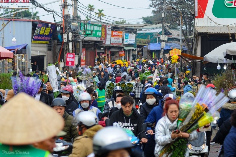 Lượng người đổ về đây đông nghịt, nhiều thời điểm lối ra vào tại chợ hoa Quảng Bá kẹt cứng, không khí vội vã bao trùm vì ai cũng muốn sớm sắm cho mình một bố hoa, cành đào... để về chơi Tết.