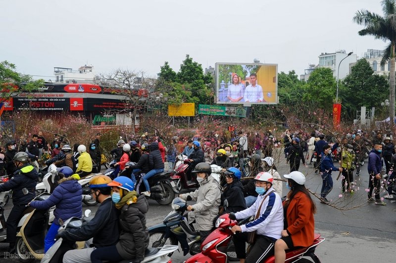 Càng chiều muộn, lượng khách đổ về đường Lạc Long Quân càng nhiều, ai cũng mong muốn chọn cho mình một bó hoa ưng ý để mang bán hoặc mang về cắm Tết khiến cho con phố trở nên tấp nập.