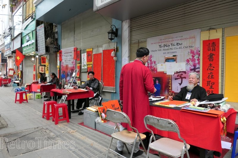 Các ông đồ già, trẻ, khăn xếp, áo the, bày mực tàu giấy đỏ cho chữ dọc tuyến đường Văn Miếu.