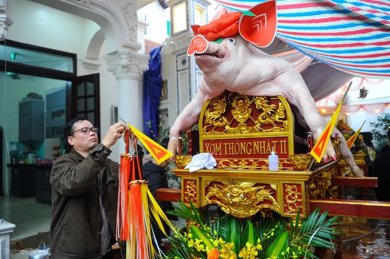 Việc trang trí mỗi 'ông lợn' thường diễn ra trong khoảng 2-3 tiếng và đòi hỏi người làm phải khéo tay và tỉ mỉ. Trong ảnh, 'ông lợn' của xóm Thống Nhất II, nặng tới 220 kg đang được trang trí những khâu cuối cùng để đưa lên đình làng tế lễ.
