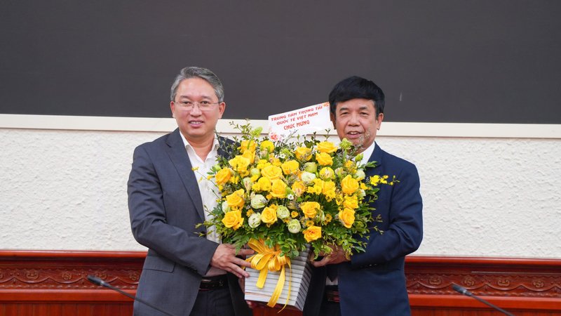 Bộ trưởng Bộ Tư pháp Nguyễn Hải Ninh nhận hoa chúc mừng từ Trung tâm Trọng tài Quốc tế Việt Nam