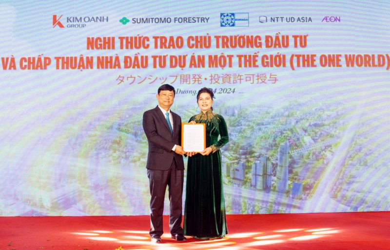 Ông Võ Văn Minh - nguyên Chủ tịch UBND tỉnh Bình Dương trao Quyết định của UBND tỉnh về chấp thuận chủ trương đầu tư và chủ đầu tư dự án Một Thế Giới - The One World cho Kim Oanh Group. (Ảnh: theoneworld.city).
