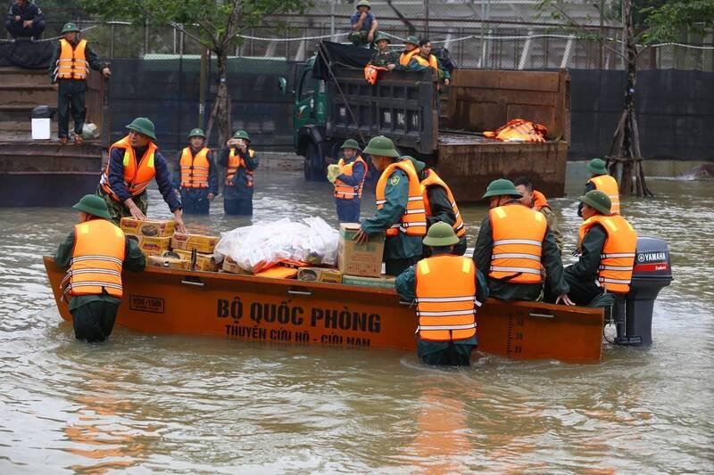 Lực lượng chức năng Hà Tĩnh dùng xuồng để cứu trợ, di chuyển người dân đang ở trong khu vực bị ngập sâu. Ảnh: Minh Quyết/TTXVN.