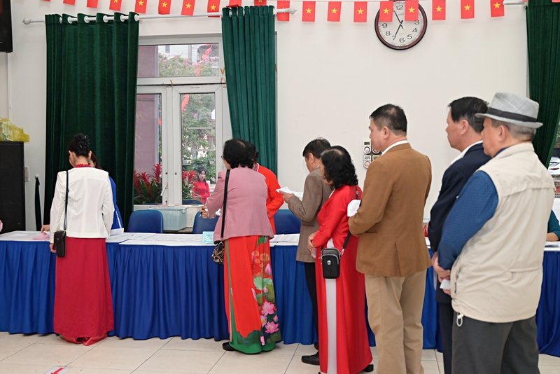 Cử tri cầm trên tay thẻ cử tri xếp hàng ngay ngắn lần lượt vào nhận phiếu bầu cử