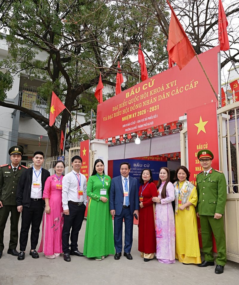 Bà Nguyễn Thị Hoài Thu và ông Nguyễn Chí Dũng chụp ảnh với đại diên tổ bầu cử tại khu vực bỏ phiếu số 3