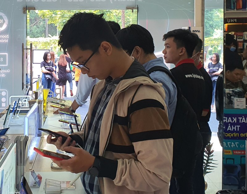 Một người dùng đang so sánh tính năng của điện thoại tầm trung để có quyết định sau cùng. Ảnh: Minh Nguyễn.