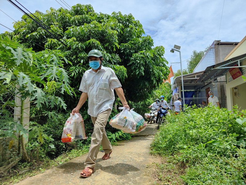 Chung tay hỗ trợ nhu yếu phẩm cho người dân khu phong tỏa. Ảnh: Minh Nguyễn.