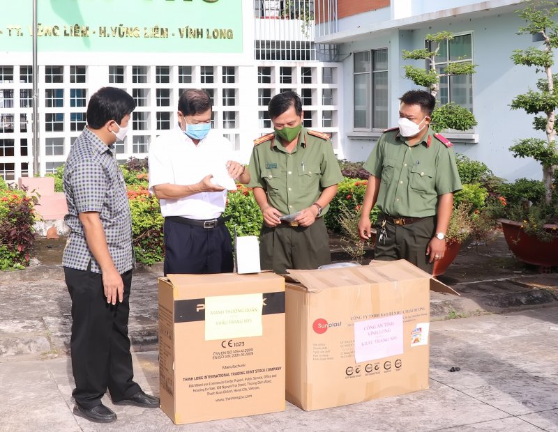 Đại tá Trần Quốc Phục (bên trái ngoài cùng) trao trang thiết bị y tế cho tuyến đầu chống dịch COVID-19 tại Vĩnh Long. Ảnh: Thảo Trần.