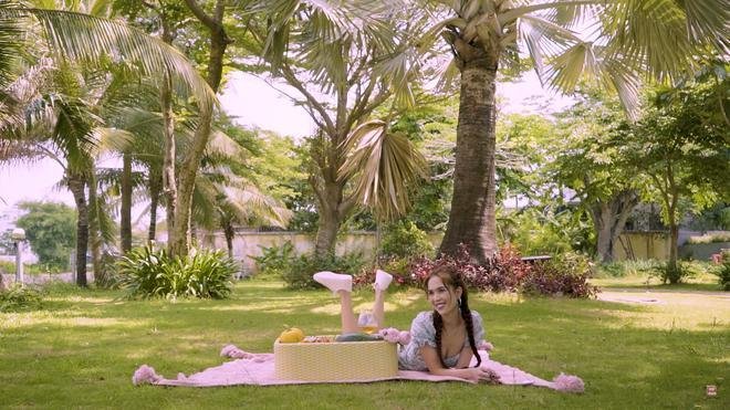 Ngọc Trinh trải thảm, mang đồ ăn giả như đi picnic trong vườn nhà.