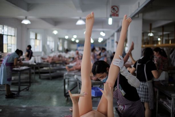 Một công nhân đang giữ lật ngược búp bê khi tiến hành lắp ráp.