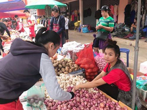 Quyên, áo đỏ, sinh sống ở Viêng Chăn được 4 năm. Ảnh: KL.
