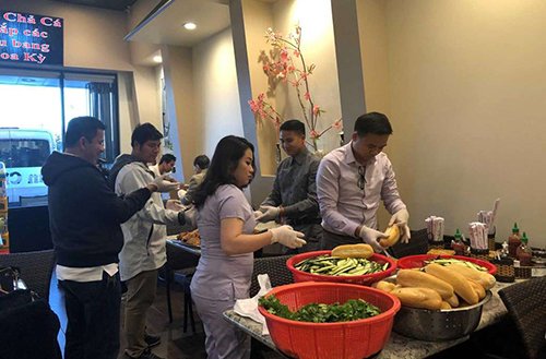 Các tình nguyện viên chuẩn bị bánh mỳ để phân phát cho người vô gia cư tại nhà hàng Bún Chả cá Đà Nẵng ở khu Alief, ngoại ô thành phố Houston hôm 26/11. Ảnh: Chron
