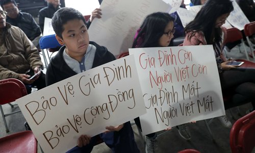 Bill Nguyen, 12 tuổi và Jade Nguyen, 9 tuổi, cầm khẩu hiệu chống lệnh trục xuất của Tổng thống Donald Trump, trong một cuộc biểu tình ở nhà thờ Mary Queen of Vietnam ở thành phố New Orleans. Ảnh: AP.