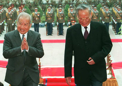 Quốc vương Campuchia Norodom Sihanouk gửi lời chào khi ông và Chủ tịch nước Việt Nam Lê Đức Anh bước vào Phủ Chủ tịch trong một buổi lễ chào mừng được tổ chức vào ngày 14/12/1995 tại Hà Nội khi quốc vương có chuyến thăm chính thức ba ngày tại Việt Nam. 