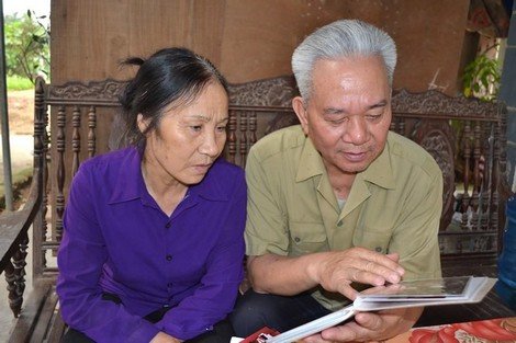 Ông Toàn và vợ xem lại những bức ảnh cưới.