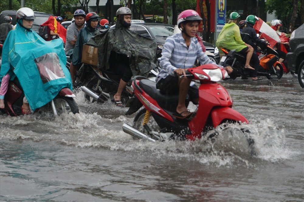 Người dân chọn lưu thông khu vực đường cao, tránh chỗ trũng nước ngập sâu.