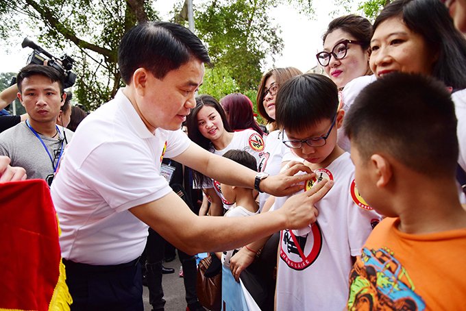 Chủ tịch TP Hà Nội - ông Nguyễn Đức Chung gắn logo lên người các em học sinh với thông điệp “Đã uống rượu bia - Không lái xe”