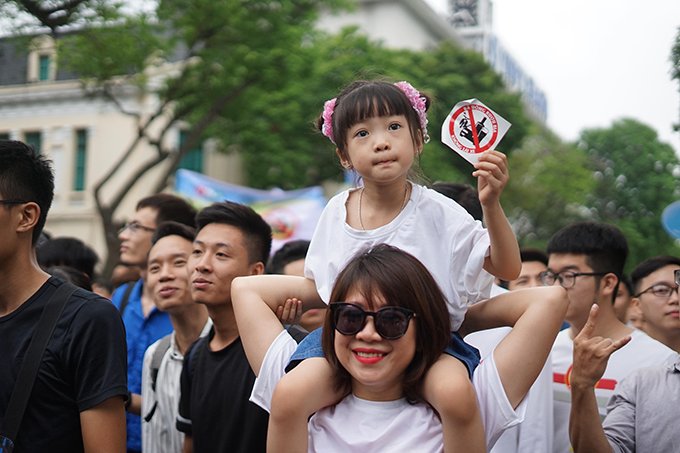 Rất nhều em nhỏ cũng được phụ huynh cõng trên vai cho đi tham dự chương trình