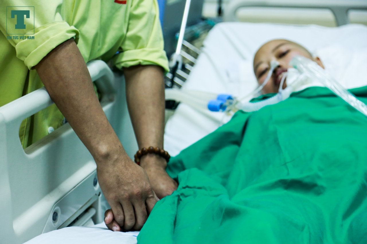 Anh Đỗ Văn Hùng không khi nào bớt được sự lo lắng, bàn tay anh nắm lấy tay vợ, ánh mắt hết nhìn chị Liên, đôi lúc lại xoay qua quan sát những chỉ số sinh tồn trên thiết bị đo đặt bên cạnh sản vợ.