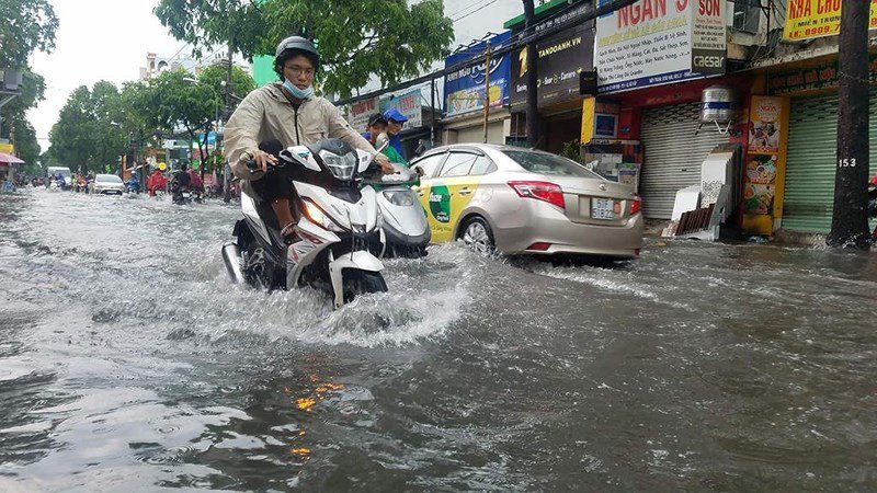 Trên đường Lê Văn Thọ (quận Gò Vấp) nước dâng cao kéo dài cục bộ ở nhiều đoạn khiến người dân đi lại khó khăn. 