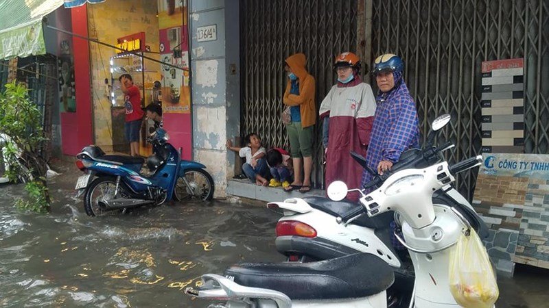 Nhiều người dân đành phải tấp vào những nhà dân bên đường để trú tránh chờ mưa ngớt mới có thể về nhà