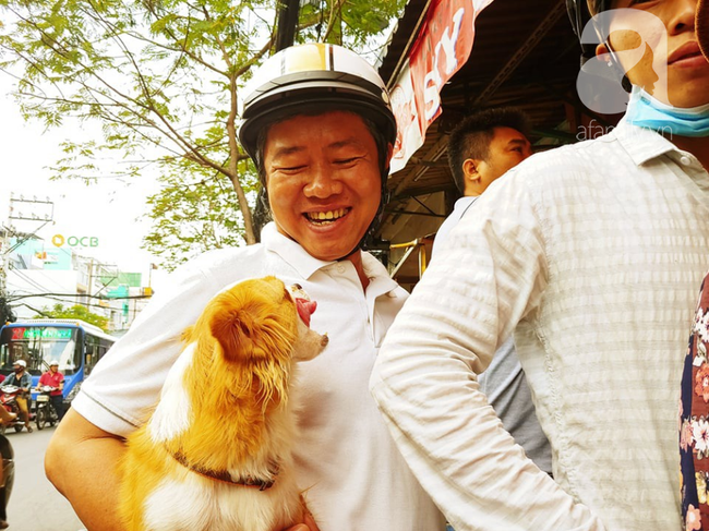 Người đàn ông ẵm theo cả chó chờ mua vịt quay.