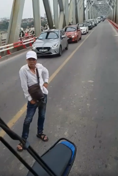 Hình ảnh nam thanh niên dựng xe máy chặn xe buýt giữa cầu Chương Dương.