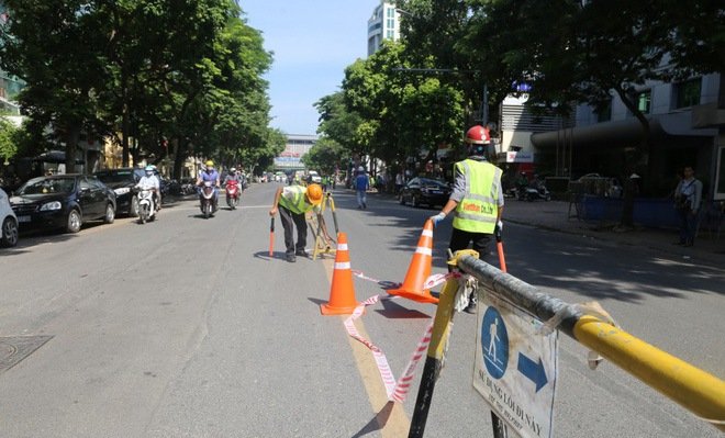 Các công nhân lập rào chắn trên đường.