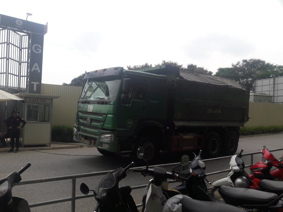 Một chiếc xe chở vật liệu xây dựng đi chuyển trong con ngõ vào công trường.