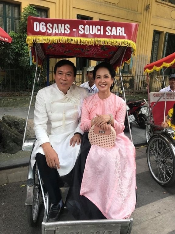 Vợ chồng nghệ sĩ Lan Hương - Đỗ Kỷ diện áo dài đôi ngồi xích lô được khen trẻ trung như tân lang tân nương. 