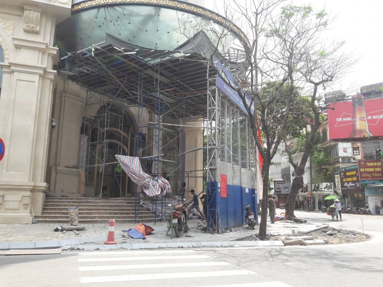 Phần giàn giáo công trình lấn chiếm toàn bộ vỉa hè khiến người đi bộ phải xuống lòng đường.