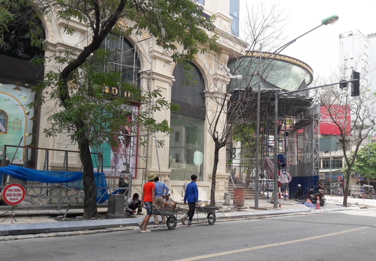 Các công nhân chở vật liệu thi công bằng xe thô sơ cũng phải đi xuống lòng đường gây nguy cơ tai nạn.