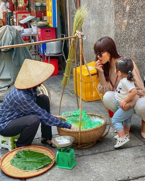 Hà Anh cùng con gái thưởng thức cốm Hà Nội. 