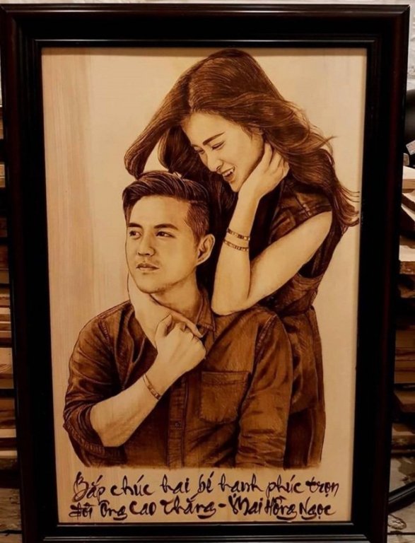 Không chỉ gửi tiền mừng, Ngô Kiến Huy còn gửi tặng Ông Cao Thắng và Đông Nhi món quà cưới độc đáo. Đó là bức tranh bút lửa trên nền gỗ, ghi lại khoảnh khắc đôi uyên ương quấn quít, mỉm cười hạnh phúc.