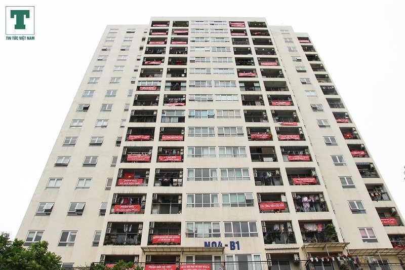 Băng rôn đỏ treo kín tòa chung cư phản đối dự án bãi xe ngầm tại công viên Cầu Giấy của Công ty cổ phần đầu tư và phát triển đô thị Tây Hồ.