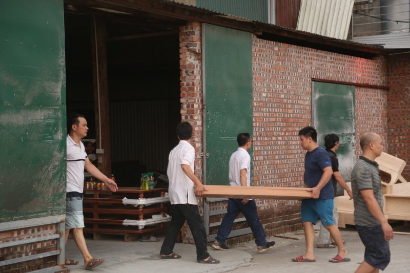 Người dân xung quanh hỗ trợ vận chuyển đồ đạc trong xưởng ra ngoài..