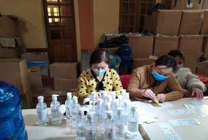 Các công nhân dán nhãn mác dung dịch bằng tay.