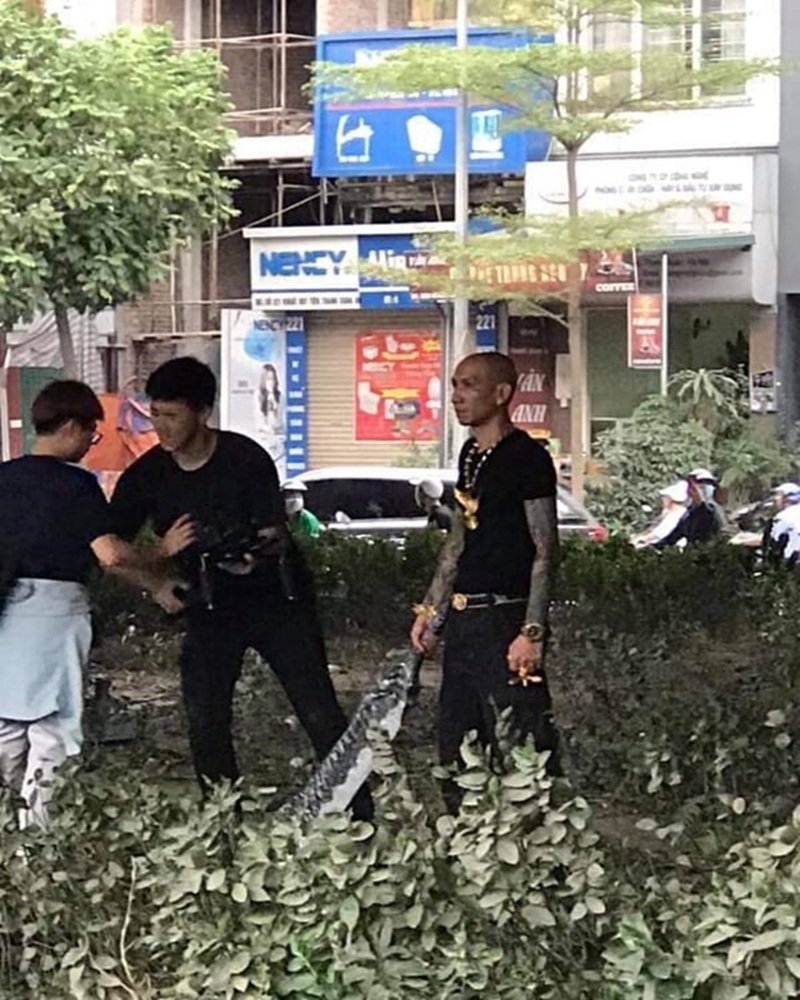 Và đây là cảnh Phú Lê cầm đao quay phim giang hồ giữa phố từng gây xôn xao mạng.