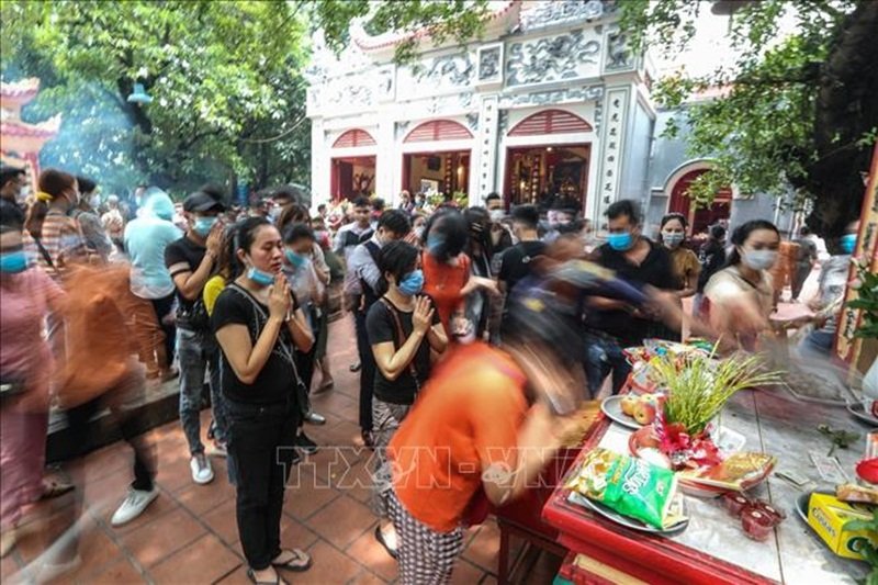 Nhiều người cho rằng khi lễ mà đeo khẩu trang là bất kính. (Ảnh: TTXVN).
