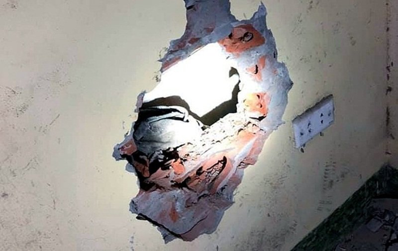 Lực lượng chức năng phải đục tường để đưa cháu bé ra ngoài an toàn.