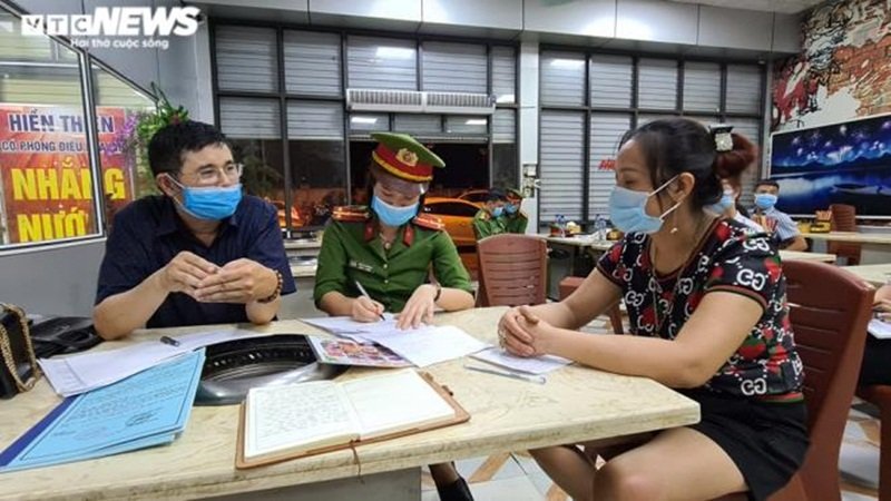 Vợ chủ quán (áo hoa) làm việc với đoàn kiểm tra. (Ảnh: VTC NEWS).