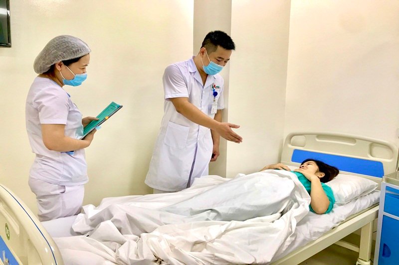 Bác sỹ CKI Hoàng Anh Tuấn- Trưởng khoa Phụ sản Bệnh viện đa khoa Yên Bình đang thăm hỏi tình hình sức khỏe của bệnh nhân Nguyễn Thị.T.. (Nguồn ảnh: Bác sỹ Khoa Phụ sản, Bệnh viện Đa khoa Yên Bình cung cấp).